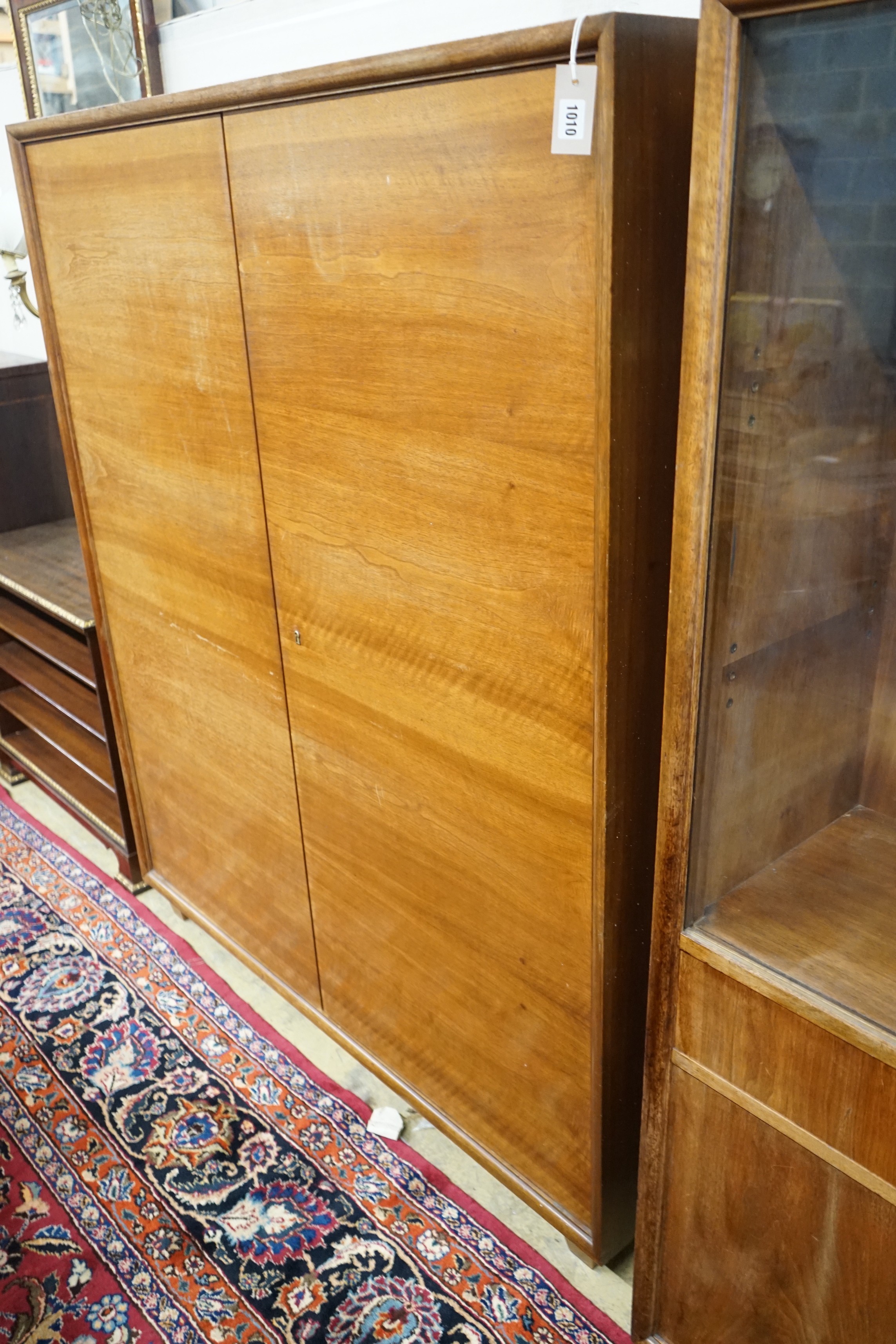 A mid century walnut two door cabinet, by Georg Schoettle, Stuttgart, width 135cm, depth 40cm, height 160cm